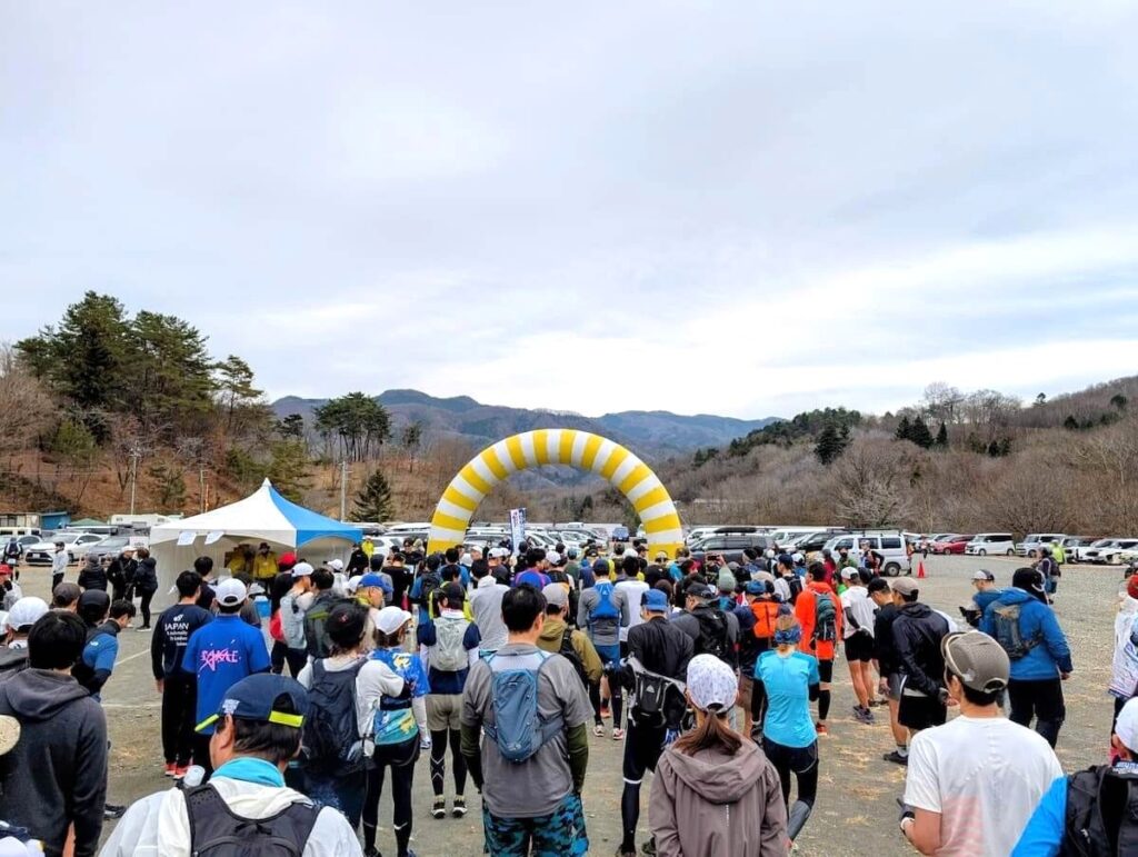 トレイルラン大会のスタート前に並ぶランナーたちの後ろ姿